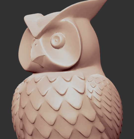 A close-up of the owl sculpture's head and chest: a round eye in a deep socket, a sharp hooked beak, a crease where the brow meets the ear tuft, and overlapping scalloped feathers across the chest, all in smooth clay-colored shading.