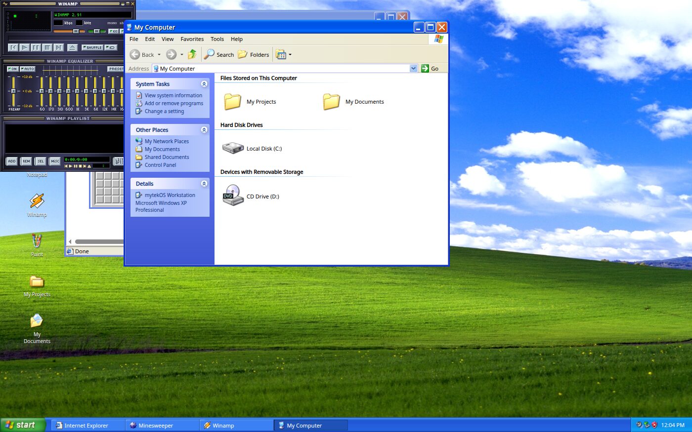 Windows XP on the green hill wallpaper with My Computer open, showing My Projects, My Documents, Local Disk C and a CD drive, and Winamp open beside it.